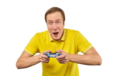 Funny gamer man with gamepad in yellow T-shirt isolated on white background. Cheerful young guy holding joy stick and playing videogames on TV, excited video game player concept