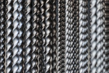 Bunch of hammer power drill bits in hardware store background, small depth of field. Power impact drill bits for working with concrete and metal surfaces, construction tool for making round holes