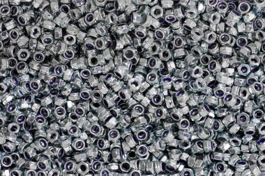 Bunch of galvanized hexagon locknuts for bolts, fasten multiple parts together, hardware fasteners. Many high-quality stainless steel lock nuts, industrial close up background