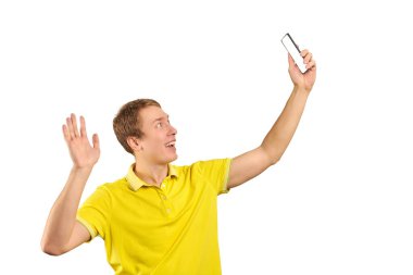 Funny guy in bright yellow T-shirt talking and video chatting using video translation with smartphone isolated on white background. Phone with white screen mockup. Funny young man taking selfie