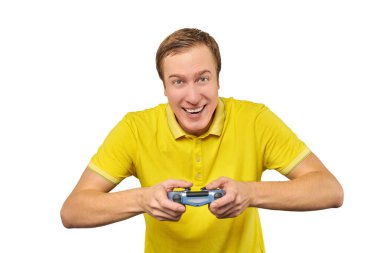 Funny gamer man with gamepad in yellow T-shirt isolated on white background. Cheerful young guy holding joy stick and playing videogames on TV, excited video game player concept