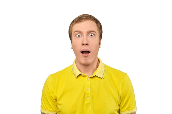 stock image Surprised young man with funny facial expression in yellow T-shirt, white isolated background. Shocked amazed young man in yellow T-shirt close up on white. Portrait of man with wide open mouth