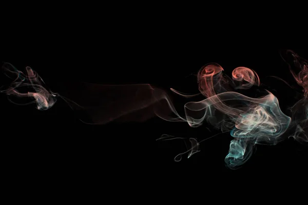 Multicolored smoke for aromatherapy and relaxation, black background, beautiful swirled puffs of smoke. Red, orange and turquoise gradient colors of dense smoke, decorative multi colour smoke curls