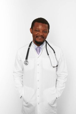Smiling black bearded doctor man in white coat with stethoscope isolated on white background. Friendly adult black african american physician therapist portrait, pleasant candid male emotion