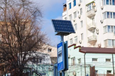 Solar panel on city road sign post, power for bus stop light, environmental friendly ecology electricity. Solar energy panel powered city infrastructure, ecological renewable solar energy