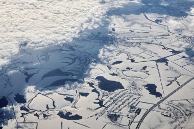 Aerial view over clouds top to snow covered rivers, fields and roads, winter fresh frosty air. Beautiful hazed sky aerial view to Earth troposphere, snowy abstract background texture clipart