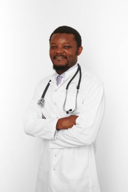 Smiling black bearded doctor man crossed arms in white robe with stethoscope isolated on white background. Adult black african american physician therapist portrait, confident candid male emotion