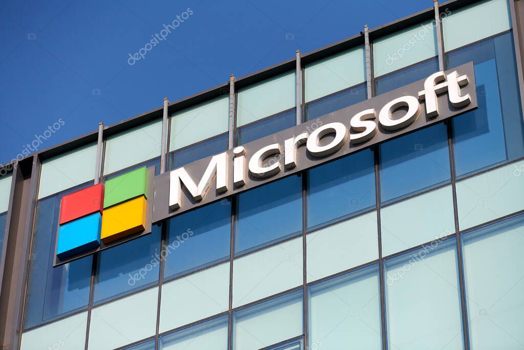 New Delhi - 08.12.2022 - Microsoft corporation brand logo on high rise glass building exterior, outdoor blue sky copy space. Microsoft software corporation head office logo on skyscraper