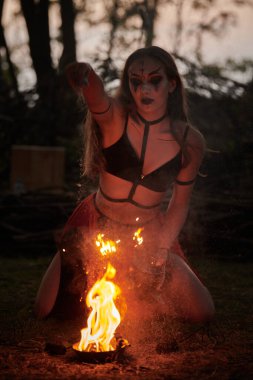 Açık hava sanat festivalinde kız ateş dansı gösterisi, dans eden kadın sanatçının ateş alevi gibi yumuşak hareketleri. Ateş sanatıyla dans eden kadın, alacakaranlık ormanı geçmişi