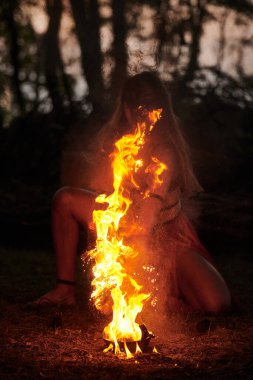 Açık hava sanat festivalinde kız ateş dansı gösterisi, dans eden kadın sanatçının ateş alevi gibi yumuşak hareketleri. Ateş sanatıyla dans eden kadın, alacakaranlık ormanı geçmişi
