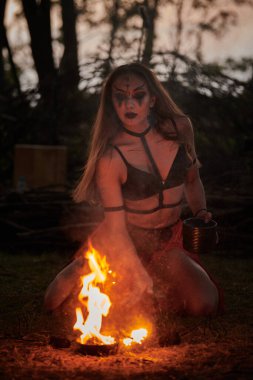 Açık hava sanat festivalinde kız ateş dansı gösterisi, dans eden kadın sanatçının ateş alevi gibi yumuşak hareketleri. Ateş sanatıyla dans eden kadın, alacakaranlık ormanı geçmişi