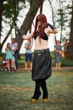 Mitolojik dansçı kız, mitolojik atmosferli açık havada halka açık parkta yeşil çimlerde dans ediyor. Narnia 'lı efsanevi yaratığın görüntüsü, dişi satir dansı.