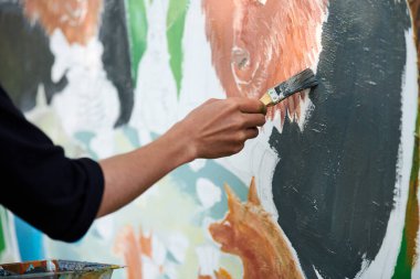 Ressam el fırçasını tutuyor ve açık hava resim festivalinde beyaz tuval üzerine soyut gerçeküstü görüntüler çiziyor, resim resim süreci. Sanatçı atmosferik resim çizer