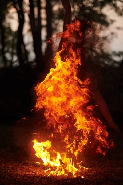 女孩在户外艺术节的火舞表演中 女艺术家的流畅动作点燃了火焰 女人跳舞与火的艺术表演 暮色的森林背景 — 图库照片