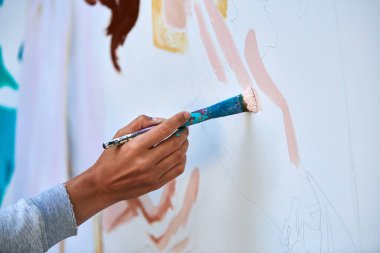 Ressam el fırçasını tutuyor ve açık hava resim festivalinde beyaz tuval üzerine soyut gerçeküstü görüntüler çiziyor, resim resim süreci. Sanatçı atmosferik resim çizer