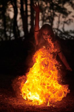 Açık hava sanat festivalinde kız ateş dansı gösterisi, dans eden kadın sanatçının ateş alevi gibi yumuşak hareketleri. Ateş sanatıyla dans eden kadın, alacakaranlık ormanı geçmişi