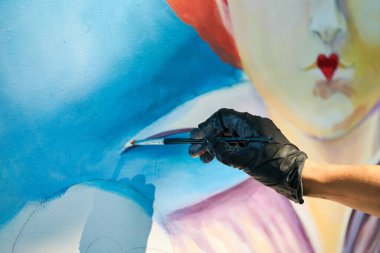 Kız sanatçı eli boya fırçasını tutuyor ve beyaz tuval resim festivaline gerçeküstü bir peri masalı portresi çiziyor, resim resim yapma sürecine. Kadın sanatçı atmosferik gerçeküstü resim çiziyor.