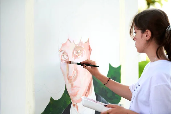Junge Künstlerin Zeichnet Mit Pinsel Männerporträt Auf Weißer Leinwand Bei — Stockfoto