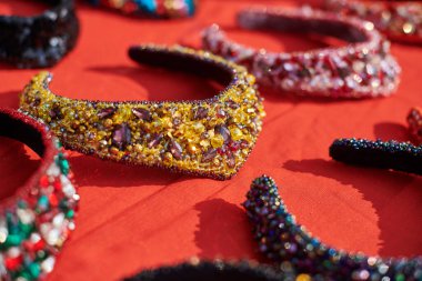 Farklı geleneksel Rus başlığı sergisi, dekoratif saç bantları kırmızı masada renkli mücevherler, Rus başlıkları boncuklu parlak mücevherler, güzel Rus saç bandı.