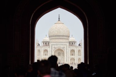 Tac Mahal girişinin ana giriş kapısı turist siluetleriyle, Taj Mahal mermer mozolesine bakın kemer, Hindistan 'da muazzam turist akını, Taj Mahal turizm sezonu