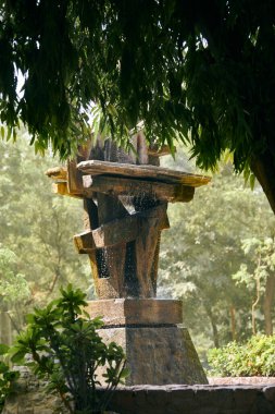 Şehir parkındaki dekoratif çeşme yeşil bitkiler arasında, soyut mimari yapı çeşmesi Yeni Delhi 'deki Lodi Garden Hint şehir parkında, dekoratif yapı Hindistan' da