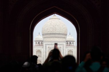 Tac Mahal girişinin ana giriş kapısı turist siluetleriyle, Taj Mahal mermer mozolesine bakın kemer, Hindistan 'da muazzam turist akını, Taj Mahal turizm sezonu