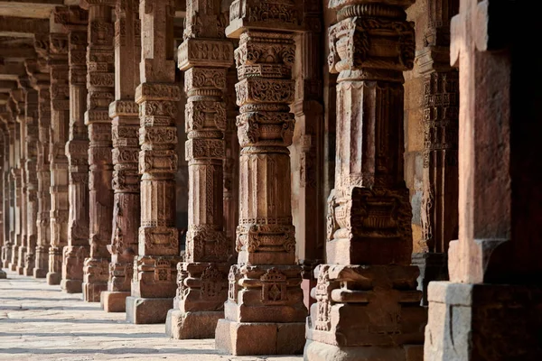 stock image Stone columns with decorative bas relief of Qutb complex in South Delhi, India, close up pillars in ancient ruins of mosque landmark, popular touristic spot in New Delhi, ancient indian architecture