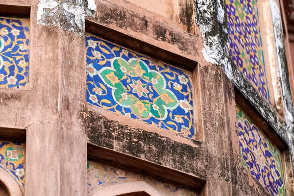 Ancient mosaic wall decoration of Agra Red Fort, beautiful colorful decorative mosaic on Red Fort wall depicting geometric patterns, old cracked ornament decoration in Agra Red Fort landmark building