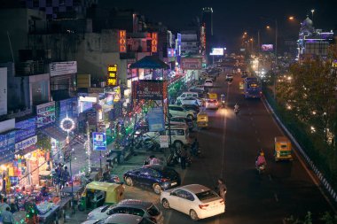 Yeni Delhi, Hindistan - 2022.10.24 - Diwali Işık Festivali için renkli çelenk ışıklarıyla süslenmiş gece karayolu, Yeşil Park 'tan karayolu manzarası, gece Hint otomobilleri yolu