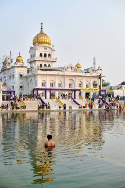 Yeni Delhi, Hindistan - 10.11.2022 - Sih, Yeni Delhi 'deki Gurudwara Bangla Sahib Tapınağı' nın kutsal göleti Sarovar 'da namaz kılıyor.