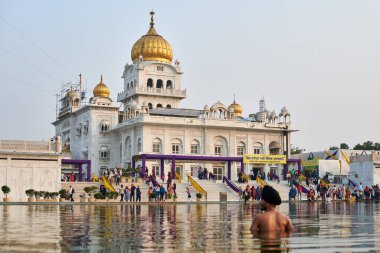 Yeni Delhi, Hindistan - 10.11.2022 - Sih, Yeni Delhi 'deki Gurudwara Bangla Sahib Tapınağı' nın kutsal göleti Sarovar 'da namaz kılıyor.