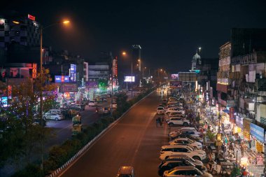 Yeni Delhi, Hindistan - 2022.10.24 - Diwali Işık Festivali için renkli çelenk ışıklarıyla süslenmiş gece karayolu, Yeşil Park 'tan karayolu manzarası, gece Hint otomobilleri yolu