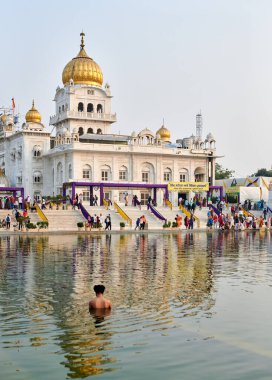Yeni Delhi, Hindistan - 10.11.2022 - Sih, Yeni Delhi 'deki Gurudwara Bangla Sahib Tapınağı' nın kutsal göleti Sarovar 'da namaz kılıyor.
