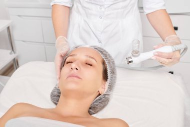 Güzellik uzmanı yüz gazı sıvı oksijen serumu epidermal kabuğunu gençleştirme için cilt bakımı, güzellik salonundaki yaşlanma karşıtı kozmetik prosedürü yapıyor. Kozmetik uzmanı yüz bakımı yapıyor