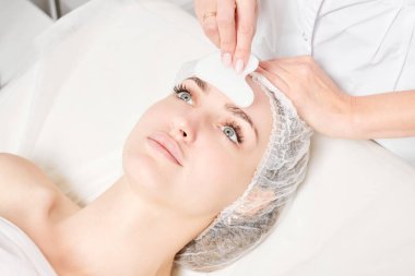 Güzellik uzmanı Gua Sha taşıyla yüz masajı yaparak güzellik salonundaki lenfatik drenaj, yaşlanmayı önleyen estetik ameliyatlar için cilde bakıyor. Gua Sha aracıyla yüz masajı