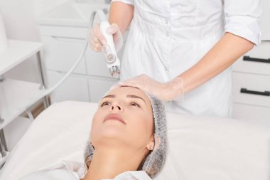 Kozmetik uzmanı yüz gazı sıvısı oksijen serumu epidermal kabuğunu gençleştirme için cilt bakımı, güzellik salonundaki yaşlanma karşıtı kozmetik prosedürü yapıyor. Güzellik uzmanı yüz bakımı yapıyor