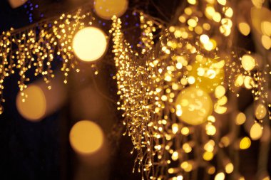 Sarı ışıklar Noel tatili çelenkleri, bulanık arka plan, soyut açık hava ışıkları ve sigara. Parlak sarı Bokeh ışıkları, güzel, karanlık gece arkaplanı.