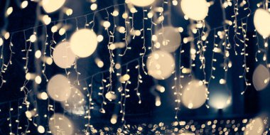 Soluk sarı ışıklar Noel tatili çelenkleri, bulanık arka plan, soyut açık hava ışıkları ve sigara. Sarımsı sahte ışıklar, gece karanlığında çok güzel parlıyor.