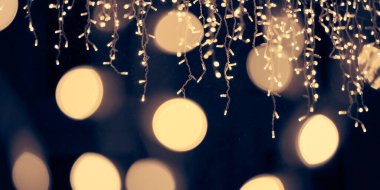 Soluk sarı ışıklar Noel tatili çelenkleri, bulanık arka plan, soyut açık hava ışıkları ve sigara. Sarımsı sahte ışıklar, gece karanlığında çok güzel parlıyor.