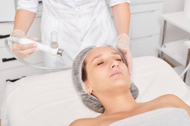 Kozmetik uzmanı yüz gazı sıvısı oksijen serumu epidermal kabuğunu gençleştirme için cilt bakımı, güzellik salonundaki yaşlanma karşıtı kozmetik prosedürü yapıyor. Güzellik uzmanı yüz bakımı yapıyor