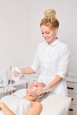 Güzellik uzmanı yüz gazı sıvı oksijen serumu epidermal kabuğunu gençleştirme için cilt bakımı, güzellik salonundaki yaşlanma karşıtı kozmetik prosedürü yapıyor. Kozmetik uzmanı yüz bakımı yapıyor