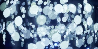 Noel tatili çelenklerinden gelen mavi ışıklar, bulanık arka plan, soyut açık hava ışıkları ve sigara. Parlak mavi Bokeh ışıkları, güzel, karanlık gece arka planında.