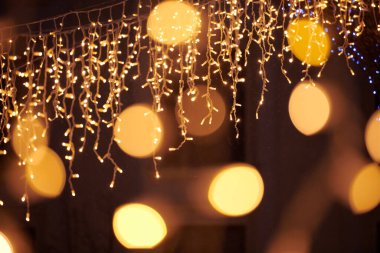 Sarı ışıklar Noel tatili çelenkleri, bulanık arka plan, soyut açık hava ışıkları ve sigara. Parlak sarı Bokeh ışıkları, güzel, karanlık gece arkaplanı.