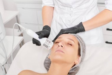 Güzellik uzmanı, gençleşen kadın yüzü için kriyoterapi yapıyor güzellik salonlarında yaşlanma karşıtı kozmetik prosedürler uyguluyor. Kozmetik uzmanı, cilt gençleştirme ve düzleştirme için kriyo terapi yapıyor.