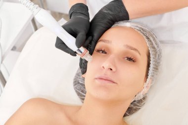 Kozmetik uzmanı, güzellik salonundaki cilt bakımı, yaşlanmayı önleyen kozmetik işlemleri ve cilt bakımını yenilemek için suda deri yüzme ameliyatı yapıyor. Siyah eldivenli güzellik uzmanları sıkılaşmak için yüz bakımı yapıyor.