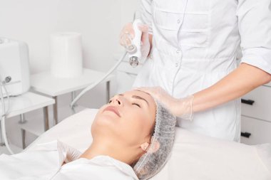 Kozmetik uzmanı yüz gazı sıvısı oksijen serumu epidermal kabuğunu gençleştirme için cilt bakımı, güzellik salonundaki yaşlanma karşıtı kozmetik prosedürü yapıyor. Güzellik uzmanı yüz bakımı yapıyor