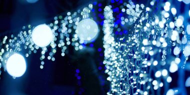 Noel tatili çelenklerinden gelen mavi ışıklar, bulanık arka plan, soyut açık hava ışıkları ve sigara. Parlak mavi Bokeh ışıkları, güzel, karanlık gece arka planında.