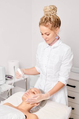 Güzellik uzmanı yüz gazı sıvı oksijen serumu epidermal kabuğunu gençleştirme için cilt bakımı, güzellik salonundaki yaşlanma karşıtı kozmetik prosedürü yapıyor. Kozmetik uzmanı yüz bakımı yapıyor