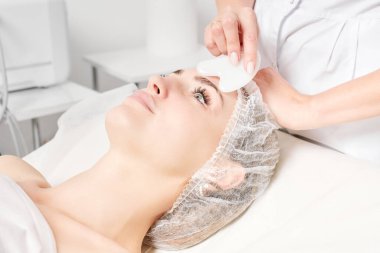 Güzellik uzmanı Gua Sha taşıyla yüz masajı yaparak güzellik salonundaki lenfatik drenaj, yaşlanmayı önleyen estetik ameliyatlar için cilde bakıyor. Gua Sha aracıyla yüz masajı