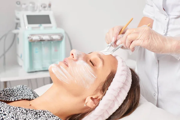 Kosmetolog Tillämpa Kosmetisk Kräm Mask Kvinnans Ansikte För Föryngring Ansikte — Stockfoto